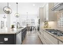 Bright kitchen boasts white cabinetry, stainless appliances, granite counters, and eat-in breakfast area at 124 Ferrell W Rd, Apex, NC 27523