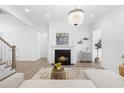 Bright living room featuring a fireplace, a decorative chandelier, and an open-concept design at 124 Ferrell W Rd, Apex, NC 27523