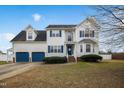 Charming two-story home with blue shutters, a two-car garage, and a beautifully landscaped front yard at 1421 Harvey Johnson Rd, Raleigh, NC 27603