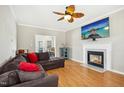 Comfortable living room features a large sectional sofa, fireplace, and a ceiling fan at 1421 Harvey Johnson Rd, Raleigh, NC 27603