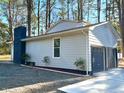 Side view of a two-car garage with a charcoal-colored chimney on a home with grey siding at 1517 Peace St, Henderson, NC 27536