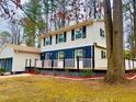 Two-story home with a wrap-around porch and a detached garage surrounded by a well-maintained yard and mature trees at 1517 Peace St, Henderson, NC 27536