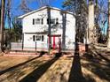 Exterior view of a two-story home with a deck, red doors, and black shutters at 1517 Peace St, Henderson, NC 27536