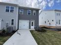 Rear view of a modern gray home featuring a two-car garage and well-maintained landscaping at 1573 Wendell Valley Blvd, Wendell, NC 27591