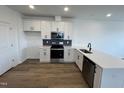 Clean kitchen featuring white cabinets, quartz countertop, stainless steel appliances, and sleek black hardware at 1573 Wendell Valley Blvd, Wendell, NC 27591