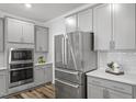 Contemporary kitchen featuring grey cabinets, stainless steel appliances and subway tile backsplash at 163 English Violet Lane Ln, Raleigh, NC 27610