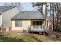 Home backyard features a small deck with stairs to a grassy backyard with mature trees at 18 Kings Mount Ct, Durham, NC 27713