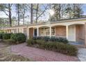 Charming brick home featuring a welcoming walkway, manicured bushes and a cozy covered front porch at 2201 Knollwood Dr, Sanford, NC 27330