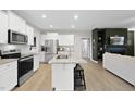 Bright kitchen featuring an island, stainless steel appliances and white cabinetry at 251 Olde Pl, Zebulon, NC 27597