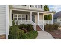 A covered front porch with white railings and stairs leading to a welcoming front door at 32 Harkers Island Dr, Garner, NC 27529
