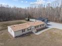 Aerial view of charming home with bricked underpinning, storage shed, and large shop building with carport at 341 Acorn Ct, Rougemont, NC 27572
