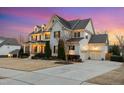 Charming two-story home with warm exterior lighting, attached garage and meticulously maintained lawn at 5025 Fanyon Way, Raleigh, NC 27612