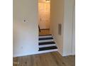 Inviting entryway with sleek black and white stairs, and light-colored wood floors at 6102 Highcastle Ct, Raleigh, NC 27613