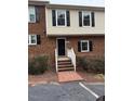 Charming brick townhouse with black shutters and a welcoming entryway staircase at 6102 Highcastle Ct, Raleigh, NC 27613