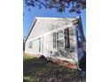 Exterior shot showcasing the home's siding, windows with black shutters, and clean design at 103 1St St, Haw River, NC 27258