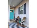 Inviting front porch with rocking chairs, black and white striped rug, and a vibrant teal door at 103 1St St, Haw River, NC 27258