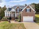 Charming two-story brick home with manicured lawn and attached two car garage at 12409 Village Gate Way, Raleigh, NC 27614