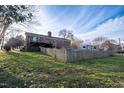 Spacious backyard featuring a wooden fence, a deck, and ample green space at 1303 Cherry Dr, Burlington, NC 27215