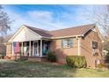 Beautiful brick home with a charming front porch, complemented by well-manicured landscaping at 1303 Cherry Dr, Burlington, NC 27215