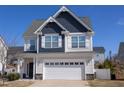 Two-story home showcases a well-manicured lawn, a two-car garage, and a combination of siding and shingles at 141 W Falcon Ct., Clayton, NC 27520