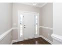 Elegant foyer with a white door, decorative molding, dark wood floors, and sidelight windows at 141 W Falcon Ct., Clayton, NC 27520