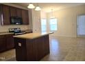 Kitchen featuring an island, dark cabinets and stainless steel microwave and oven at 2015 Tennessee Road Rd, Durham, NC 27704