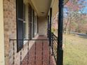Long brick porch with iron railing, columns, and exterior shutters adding curb appeal to the home at 209 Reade Dr, Roxboro, NC 27573