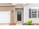 Up-close exterior showcasing the front door, brick accents, and window with a dark shutter at 2558 Summersby Dr, Mebane, NC 27302