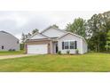 Well-maintained single-Gathering home features a lush lawn, side yard, and classic architectural details at 2558 Summersby Dr, Mebane, NC 27302