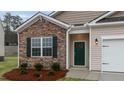 Close up of the front entrance showing stone veneer, craftsman detail and a green front door at 2566 Summersby Dr, Mebane, NC 27302