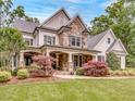 Charming two-story home with stone and siding, featuring a cozy front porch with stone columns and manicured landscaping at 2617 Jones Ferry Rd, Chapel Hill, NC 27516