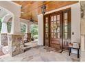 Elegant front porch with a wood ceiling, stone pillars, flagstone flooring, and a grand double door entrance at 2617 Jones Ferry Rd, Chapel Hill, NC 27516