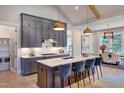 Modern kitchen with gray cabinets, marble countertops, and island seating at 3218 Bruce Garner Rd, Creedmoor, NC 27522