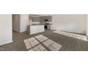 A spacious living room features wood-look flooring with an open view into the kitchen at 401 Citron St, Sanford, NC 27332