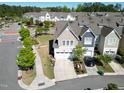 Inviting townhome showcasing an attached garage, lush landscaping, and a paved driveway at 4137 Strendal Dr, Cary, NC 27519