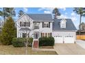 Charming two-story home with a well-manicured lawn, mature bushes, and a two car garage at 415 Moonlight Dr, Fuquay Varina, NC 27526