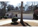 Charming single-story home with an attached garage, manicured lawn, and mature trees at 4332 Blossom Hill Ct, Raleigh, NC 27613