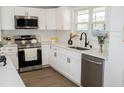 Well-lit kitchen with stainless appliances, white cabinets and subway tile backsplash at 5845 Farmwell Road Rd, Raleigh, NC 27610