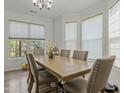 Bright dining room featuring a large table, six chairs, and natural light from bay windows at 6306 Winding Arch Dr, Durham, NC 27713