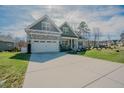 Attractive home featuring an extra long driveway and a stone-accented attached garage at 65 Walking Trl, Youngsville, NC 27596