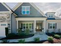 Nice exterior view of home featuring a covered porch with rocking chairs and manicured shrubs at 65 Walking Trl, Youngsville, NC 27596