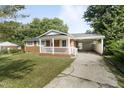 Attractive brick home featuring a covered porch and side carport, set in a leafy landscape at 709 Fitzgerald Dr, Raleigh, NC 27610