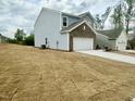 Side view of a two-story home with a spacious garage and neutral-colored siding at 801 Berkeley Glen Rd, Zebulon, NC 27597
