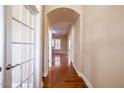 Bright hallway featuring hardwood floors and a decorative archway, leading into the home at 804 Long Meadows Rd, Chapel Hill, NC 27516