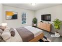 This staged bedroom features a wooden bed frame and dresser with plants and modern decor at 8425 Fawncrest Dr, Raleigh, NC 27603