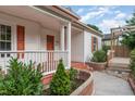 View of the front porch and walkway surrounded by attractive landscaping and a pergola at 905 N Hyde Park Ave, Durham, NC 27701