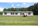 Well-maintained single-story home with a lush green lawn and classic architectural details at 9115 Nc 157, Rougemont, NC 27572