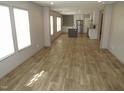 Spacious living room with light-colored wood-look floors and abundant natural light. White kitchen in the background at 9115 Nc 157, Rougemont, NC 27572
