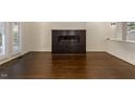 Bright living room features a fireplace, French doors and dark-stained hardwood flooring at 9413 Lake Villa Way, Raleigh, NC 27614