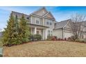 Inviting two-story home with a manicured lawn, attractive landscaping, and a welcoming front porch at 104 Red Bark Ct, Apex, NC 27539